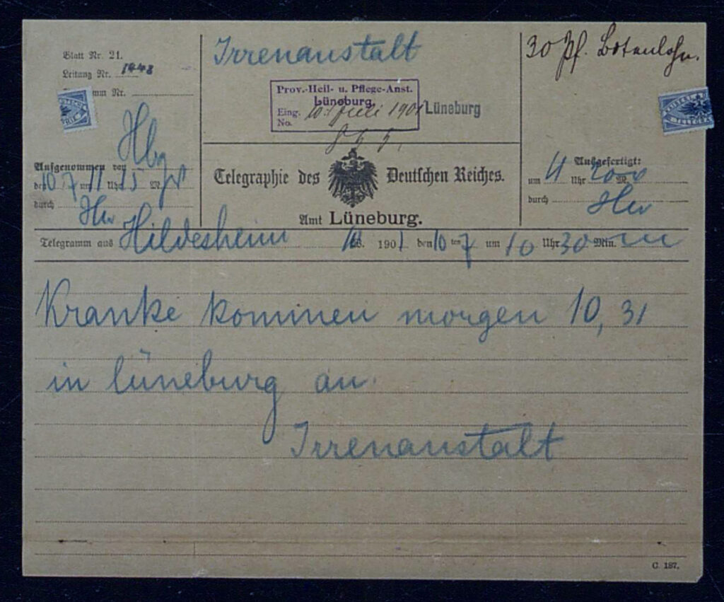 Es ist ein vergilbtes Formular im DIN A5 Format. Es ist ein Telegramm des Deutschen Reiches. Auf dem Vordruck ist in der Mitte der Reichsadler und ein Verweis auf das Amt Lüneburg. Das Telegramm ist mit einem blauen Buntstift ausgefüllt. Unter anderem steht darauf: »Kranke kommen morgen 10.30 in Lüneburg an. Irrenanstalt.