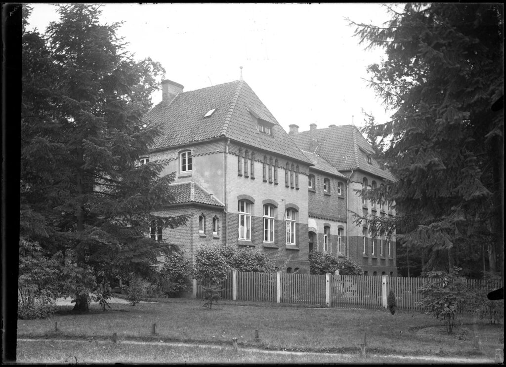 Es ist ein schwarz-weißes Foto. Es zeigt ein großes Backsteingebäude. Es gibt zwei Geschosse. Der Krankenpavillon ähnelt den Gebäuden der Heil- und Pflegeanstalt Lüneburg.
