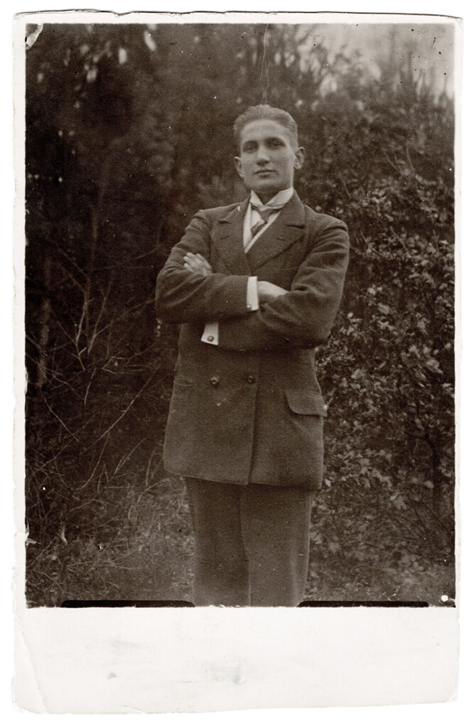 Es ist ein schwarz-weißes Foto von Oskar Pohlmann. Es ist eine Halbtotale, sodass er nur bis zu den Knien zu erkennen ist. Er steht in einem Garten mit verschränkten Armen vor der Brust. Er trägt die Haare nach hinten gebürstet. Er trägt einen dunklen Wollanzug, ein helles Hemd und Krawatte. Die Jacke ist zweireihig geknöpft. Er blickt mit leicht gehobenem Kopf ernst in die Kamera.