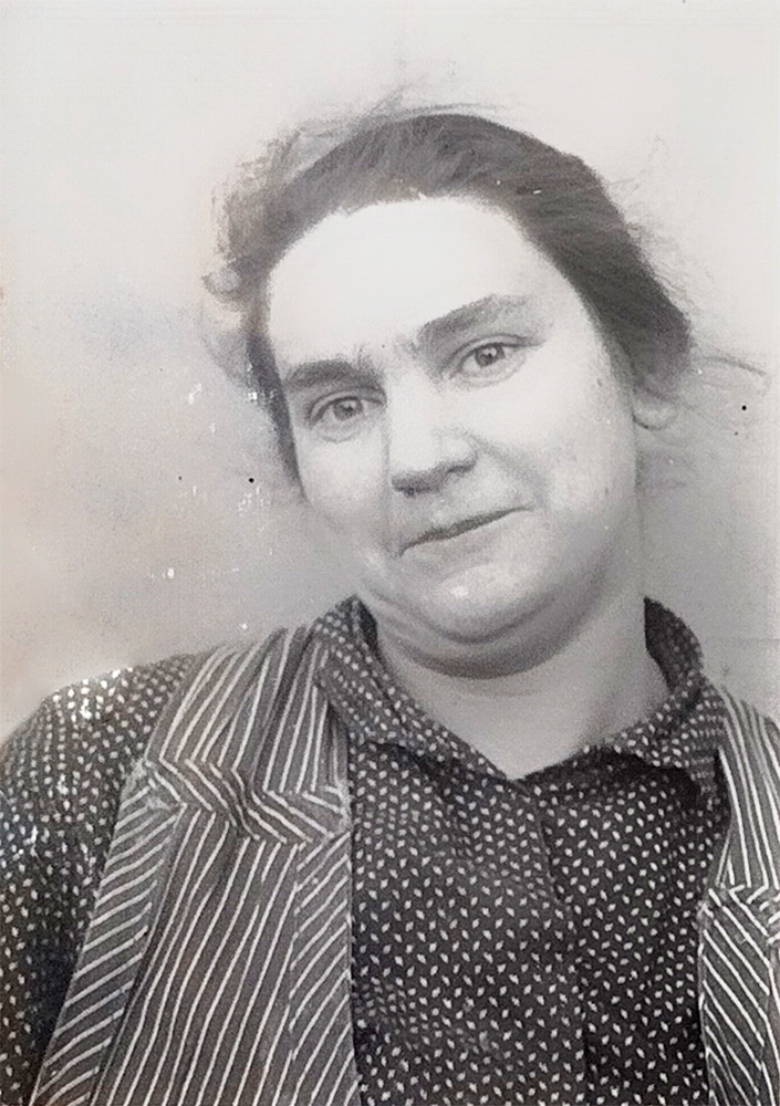 Das Passbild ist schwarz-weiß. Martha Kaufmann trägt ein gepunktetes Hemd mit gestreifter Weste. Die Haare sind locker zurückgesteckt und sie blickt mit geschlossenem Mund leicht lächelnd direkt in die Kamera. Der Kopf ist leicht nach rechts geneigt.