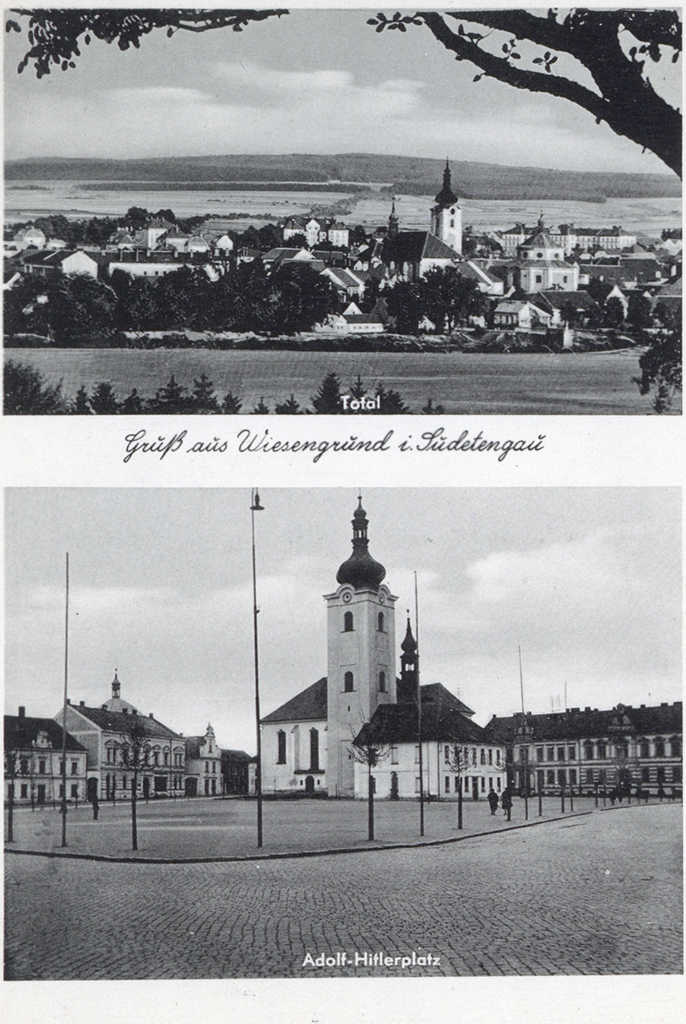 The postcard shows two black and white pictures. The lower one is an overall view of the settlement. Many houses can be seen in the middle of other fields. In the centre is a church with an onion dome. The lower picture shows Adolf Hitler Square. Behind a paved square is a church building with a high onion dome. The square is lined with tall flagpoles and young trees.