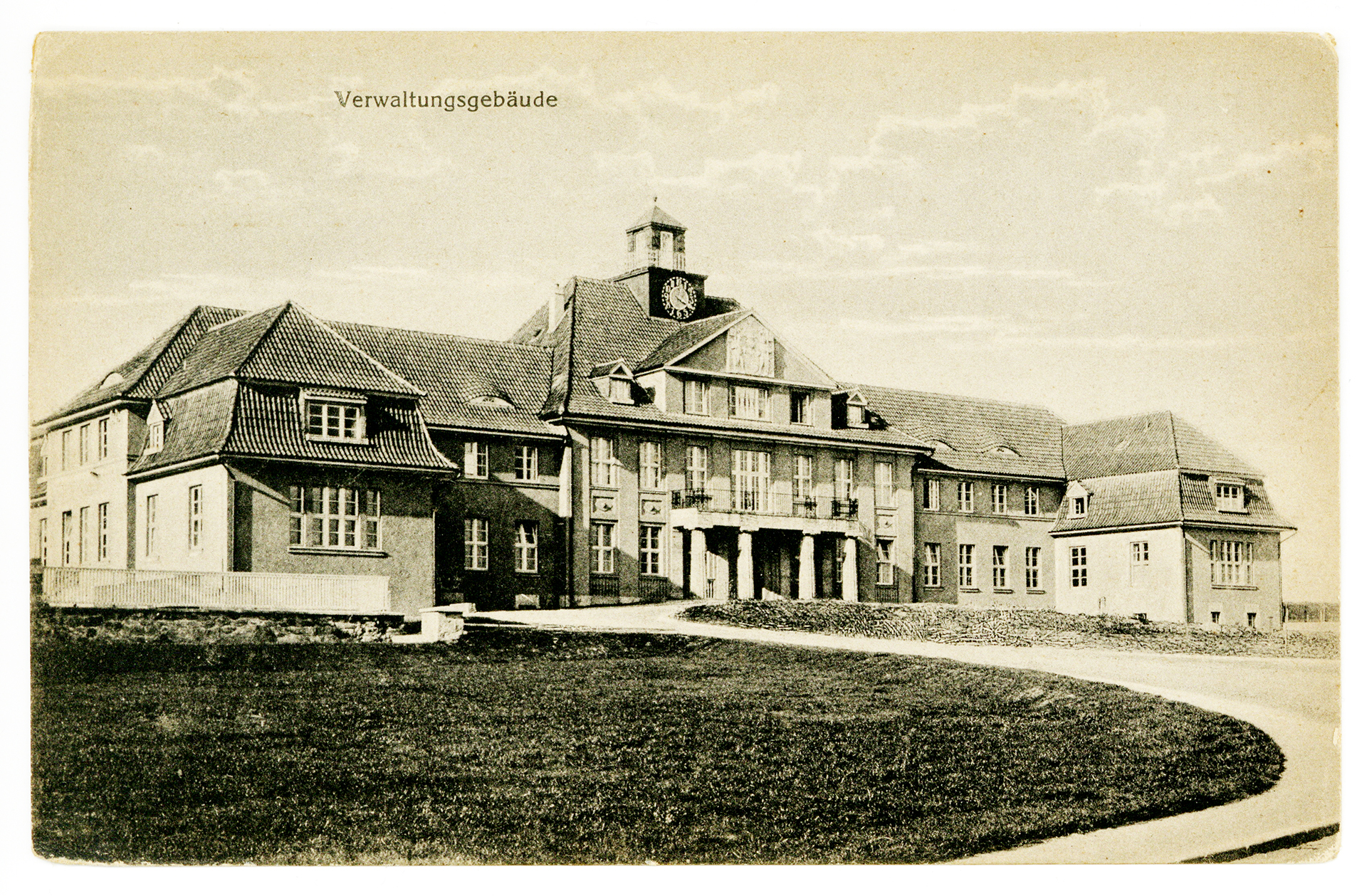 Die vergilbte Postkarte zeigt das Verwaltungsgebäude von Pfafferode. Das Gebäude hat ein zentrales Eingangshaus und davon abgehend zu jeder Seite einen Flügel mit Vorbau. Das Gebäude ist im Hauptportal zweistöckig mit einer Turmuhr auf dem Dach. Die Seitenflügel des Gebäudes sind einstöckig, wobei das Dachgeschoss Gauben hat und vermutlich auch genutzt wird. Das Gebäude ist verputzt und hat helle Sprossenfenster.