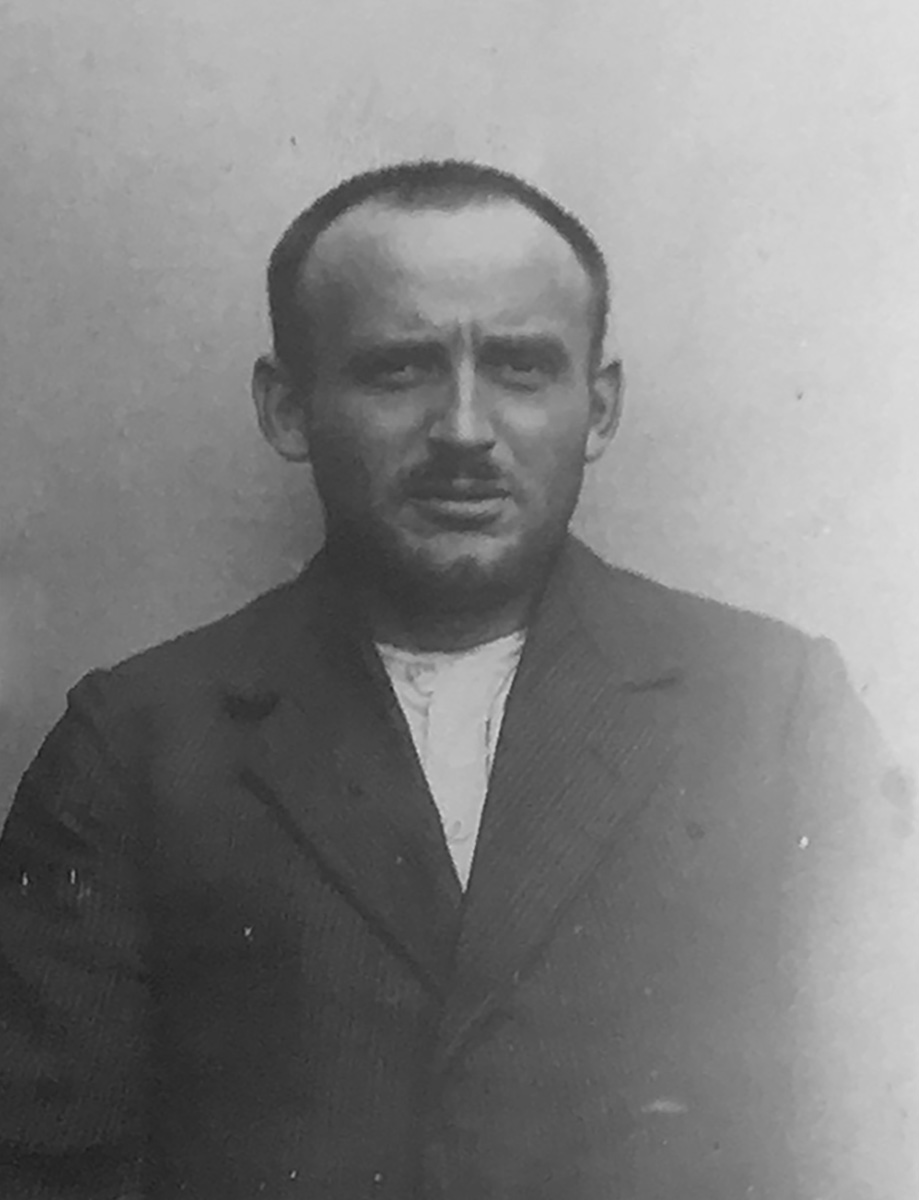 Jest to czarno-białe zdjęcie portretowe Petera Schwambergera. Ma on na sobie ciemną marynarkę i białą podkoszulkę. Ma brodę. Patrzy poważnie w obiektyw aparatu.