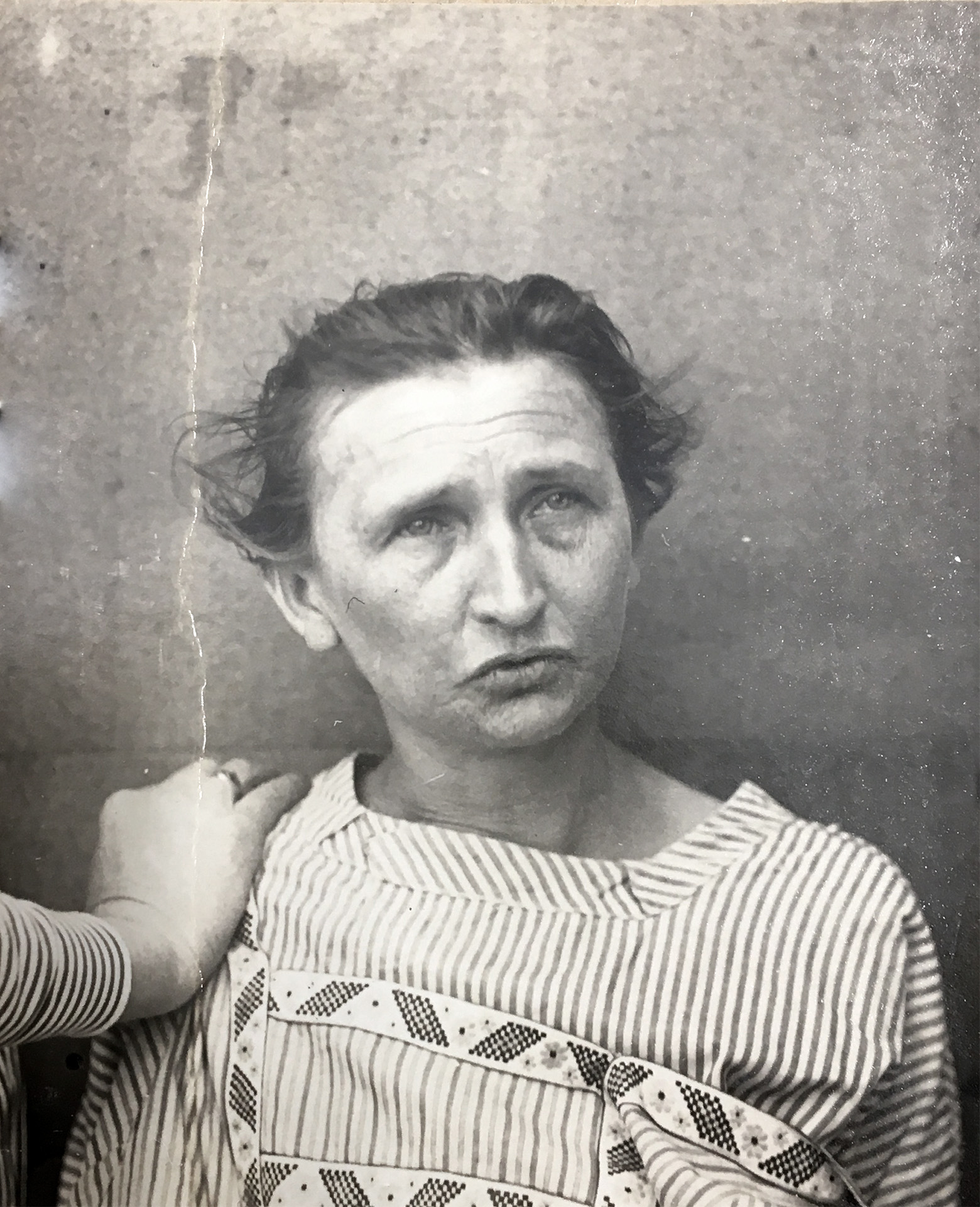 Jest to czarno-biały portret Anny Schwarz. Ma na sobie koszulę w paski, być może szpitalną. Jej włosy są lekko związane z tyłu. Patrzy w górę w prawo z lekko zaciśniętymi ustami. Ręka nieznanej osoby jest widoczna na jej lewym ramieniu i wydaje się, że popycha ją do tyłu.