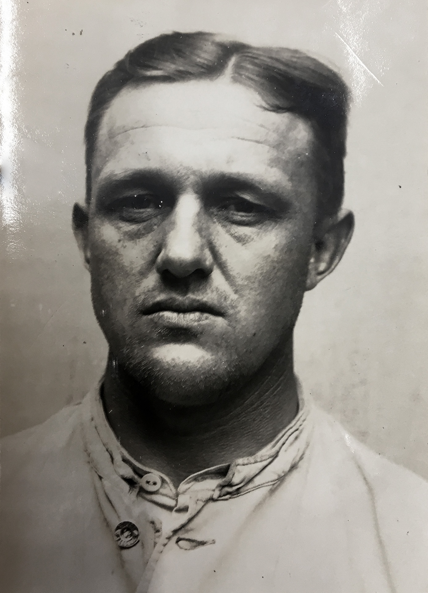 To czarno-biały portret. Adolf Veersmann ma na sobie jasną koszulę. Patrzy prosto w obiektyw z zamkniętymi ustami. Ma włosy zaczesane na bok.