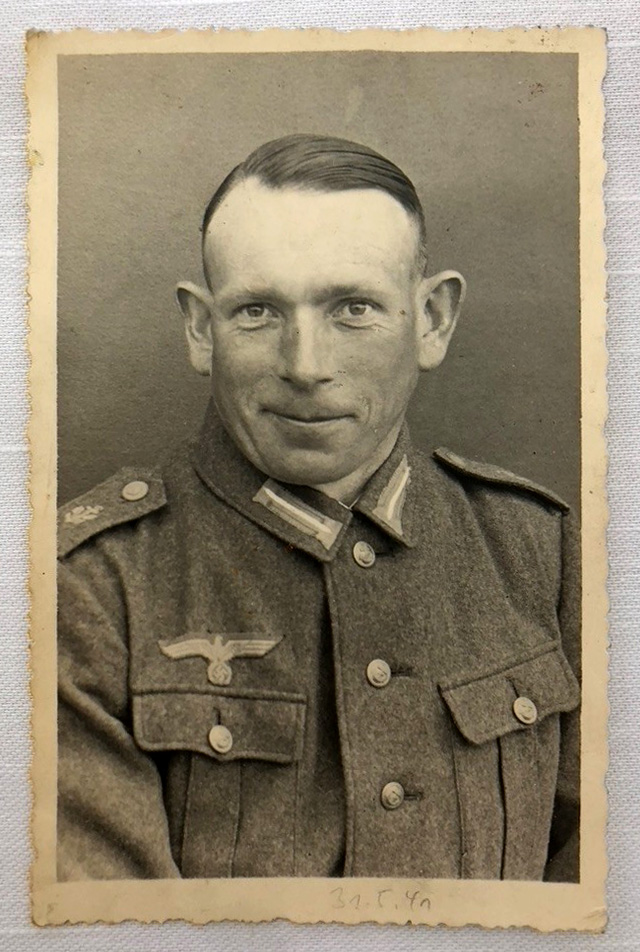 Es ist ein schwarz-weiß Portraitfoto. Johann Wojanowski trägt militärische Uniform. Seine Haare sind streng gescheitelt. Er guckt direkt zur Kamera und grinst mit schelmischen Blick.