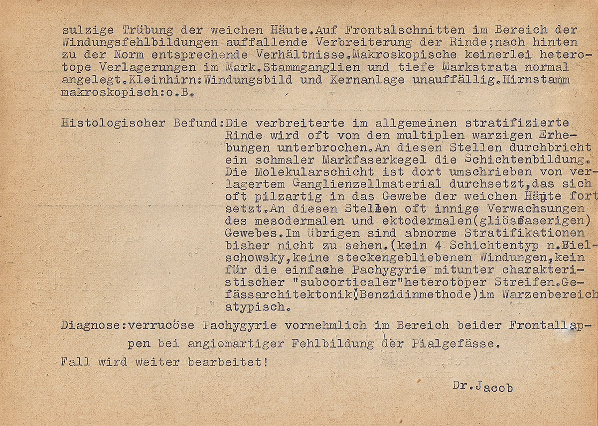 Die Rückseite der Mitschrift ist leicht vergilbt. Das Blatt ist etwa DIN-A5-groß und gelocht. Es ist mit der Schreibmaschine beschrieben. Unten rechts steht »Dr. Jacob« getippt.