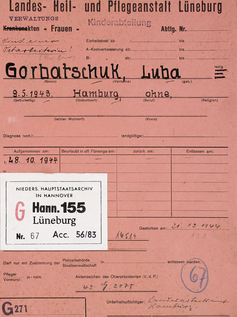 Der Deckel ist aus roter Pappe. Die vorgedruckten Kategorien sind handschriftlich ausgefüllt. Ein Aufkleber des Staatsarchivs ist aufgeklebt. Handschriftlich ist zudem hervorgehoben »Kind einer Mitarbeiterin«.