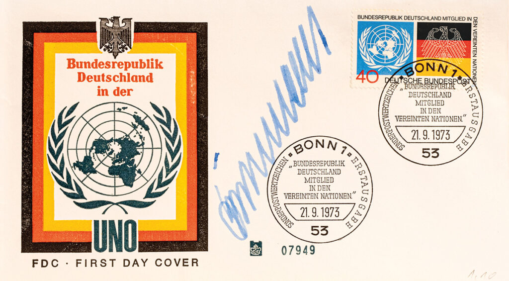 Es ist ein weißer Briefumschlag. Aufgedruckt ist ein Logo der Bundesrepublik Deutschland bei den Vereinten Nationen. Rechts daneben ist die Unterschrift von Gustav Heinemann und eine Briefmarke mit dem Logo der UN und der Flagge der Bundesrepublik.