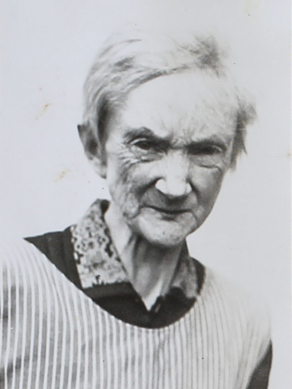 Es ist ein schwarz-weißes Porträtfoto. Marie Bagunk steht leicht seitlich zur Kamera. Sie trägt eine helle Jacke mit einer dunklen Bluse mit geblümtem Kragen. Ihr kurzes helles Haare ist gekämmt. Ihre Augen sind leicht zusammengekniffen. Ihr Blick wirkt skeptisch.